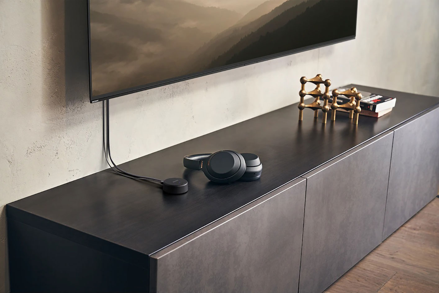 The ULT WEAR headphones connected to a BRAVIA television set by a wired cable.