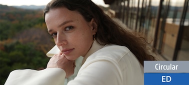 A portrait of a female gazing gently at this lens. She was shot from close angle. However, the photo leaves the viewer with an impression of depth