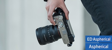 View of camera and lens held in user’s hand, showing the compact lens size