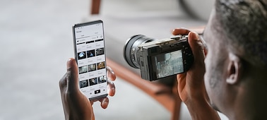 Usage image of a man transferring photos to a smartphone from the camera