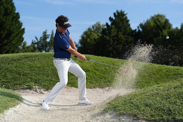 Exemplo de imagem de um golfista a dar uma tacada num bunker, momentos depois de o taco acertar na bola